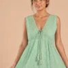 Detalle del escote en V, encaje y borlas del vestido verde menta
