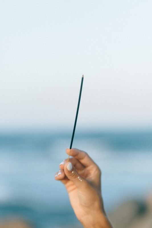 person holding incense stick